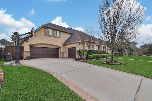 view of front of house with concrete driveway, stone siding, an attached garage, a front lawn, and stucco siding