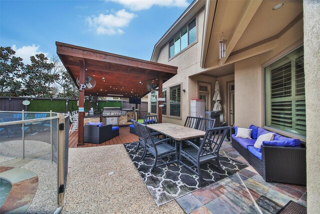 view of patio / terrace with an outdoor kitchen, grilling area, a wooden deck, an outdoor living space, and outdoor dining space