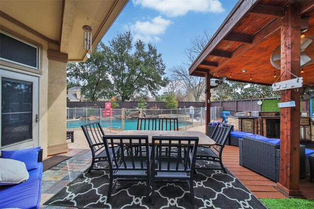 view of patio / terrace with a fenced in pool, area for grilling, a fenced backyard, outdoor wet bar, and outdoor dining space