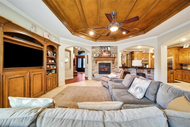 living room with ornamental molding, a tray ceiling, wooden ceiling, and a fireplace