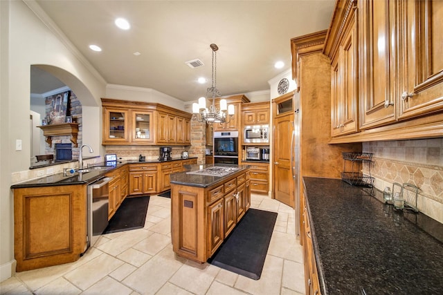 kitchen with a center island, brown cabinets, visible vents, appliances with stainless steel finishes, and a sink