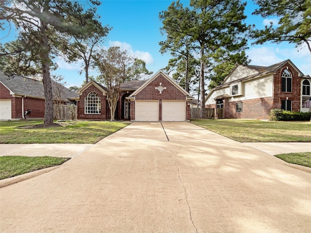 view of front of home with driveway, brick siding, a front yard, and fence