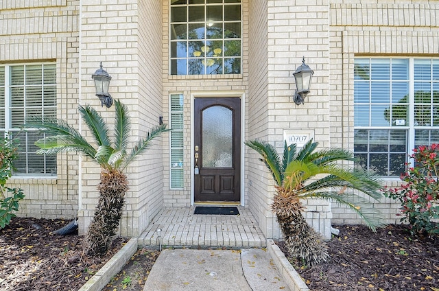 entrance to property featuring brick siding