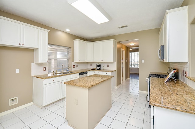 kitchen featuring light tile patterned floors, appliances with stainless steel finishes, backsplash, and a sink