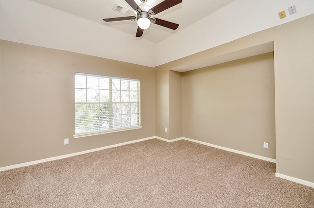 carpeted spare room featuring lofted ceiling, visible vents, baseboards, and ceiling fan