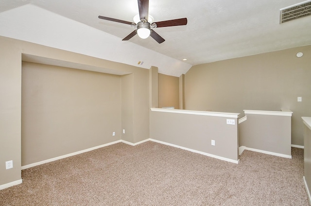 carpeted empty room with lofted ceiling, baseboards, and visible vents