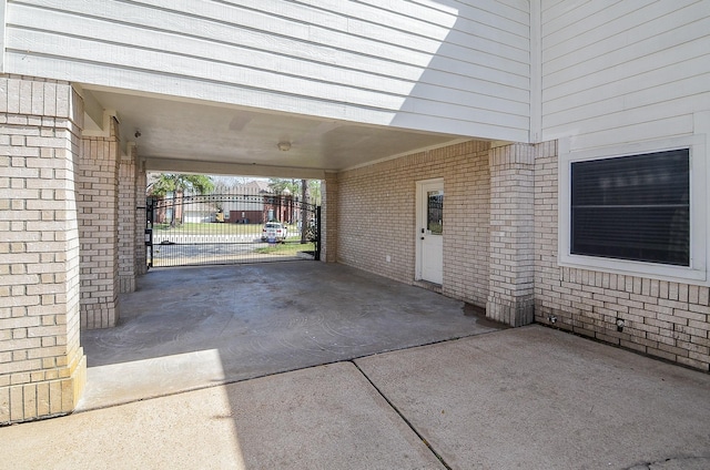 exterior space featuring a carport, concrete driveway, and a gate