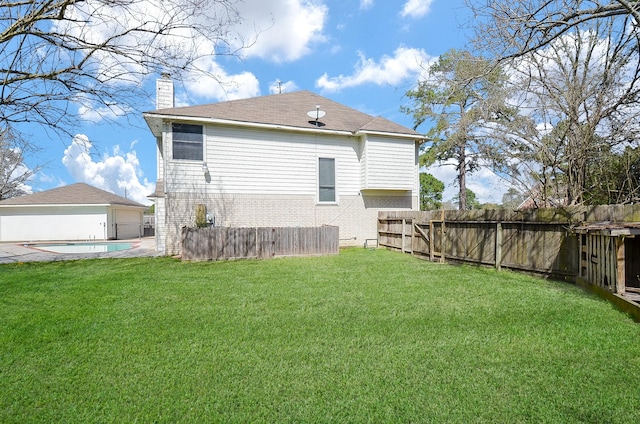 rear view of house with a fenced in pool, a lawn, a chimney, and fence