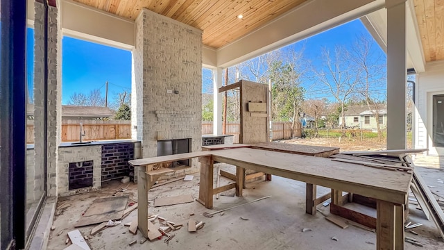 view of patio / terrace with fence and exterior fireplace