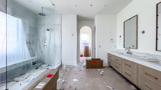 full bathroom featuring a walk in shower and vanity