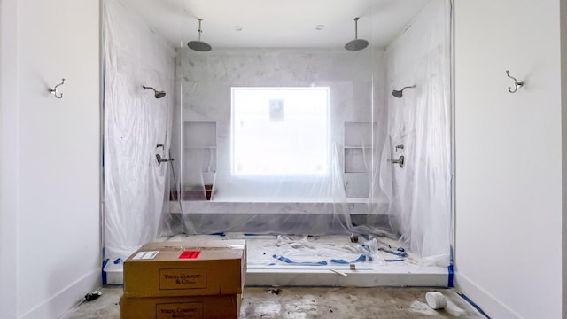 bathroom with a shower stall and unfinished concrete floors