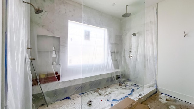 full bath with a wealth of natural light and a marble finish shower