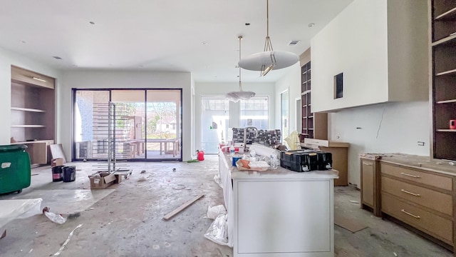 kitchen featuring built in shelves, visible vents, light countertops, hanging light fixtures, and open shelves