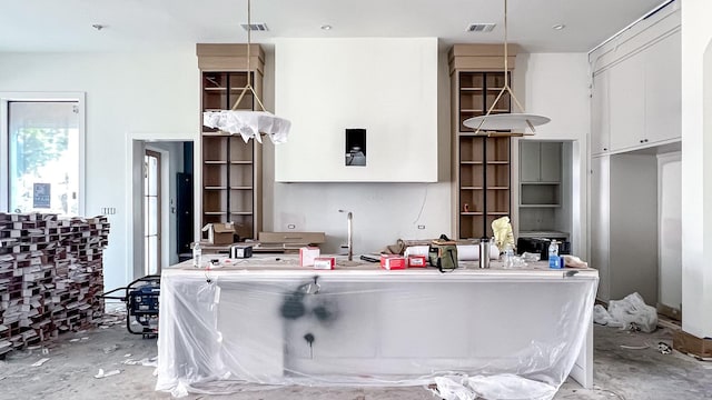 kitchen with hanging light fixtures, white cabinetry, and visible vents