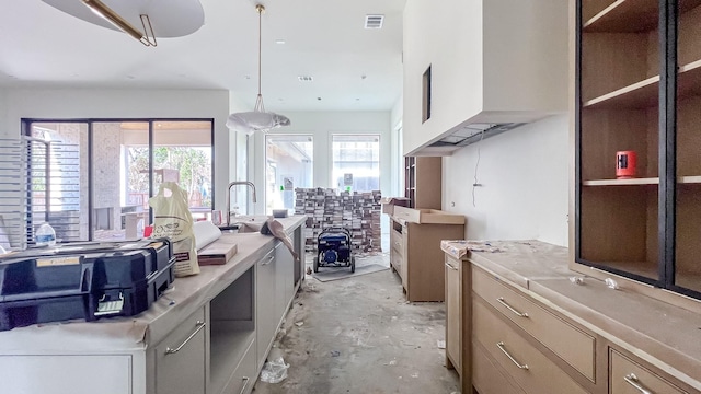 kitchen with pendant lighting, light countertops, visible vents, and unfinished concrete floors