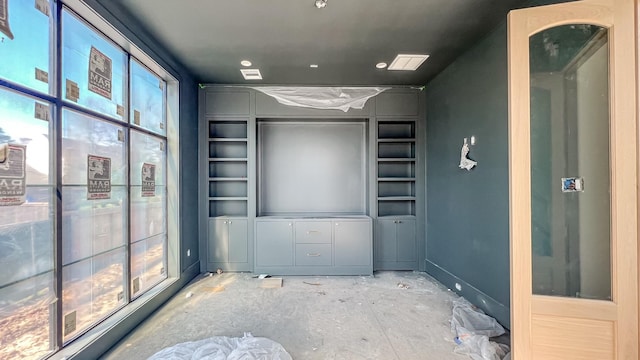 empty room featuring unfinished concrete floors and baseboards