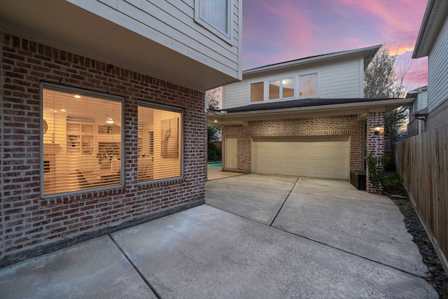 exterior space with fence, a garage, and driveway