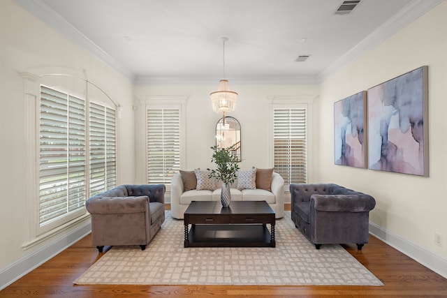 living room featuring visible vents, baseboards, wood finished floors, and crown molding