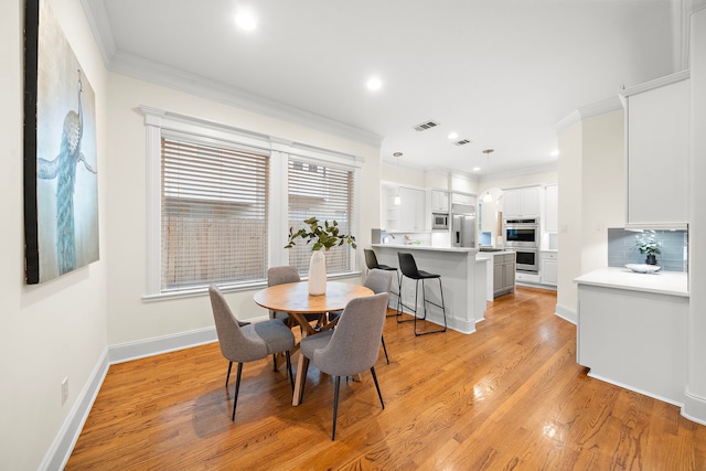 dining space featuring visible vents, baseboards, recessed lighting, light wood-style floors, and crown molding