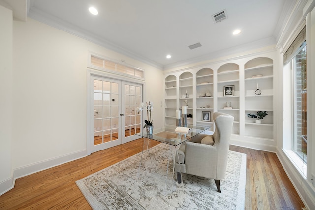 living area with french doors, wood finished floors, baseboards, and ornamental molding