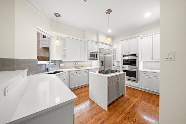 kitchen with tasteful backsplash, light wood finished floors, crown molding, built in appliances, and a sink