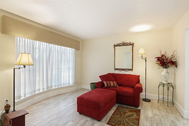 sitting room with baseboards and wood finished floors