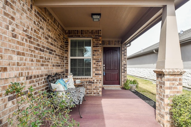 view of exterior entry with brick siding