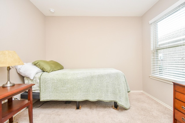 carpeted bedroom with multiple windows and baseboards