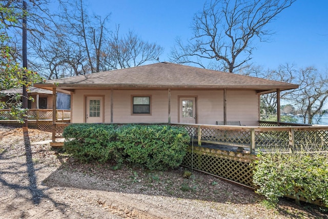 view of front of property with a shingled roof and a deck