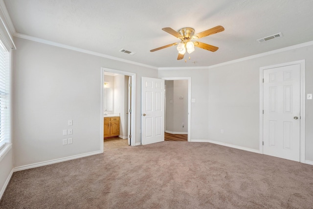 unfurnished bedroom featuring crown molding, baseboards, visible vents, and light colored carpet