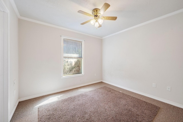 carpeted empty room with ornamental molding, baseboards, and a ceiling fan