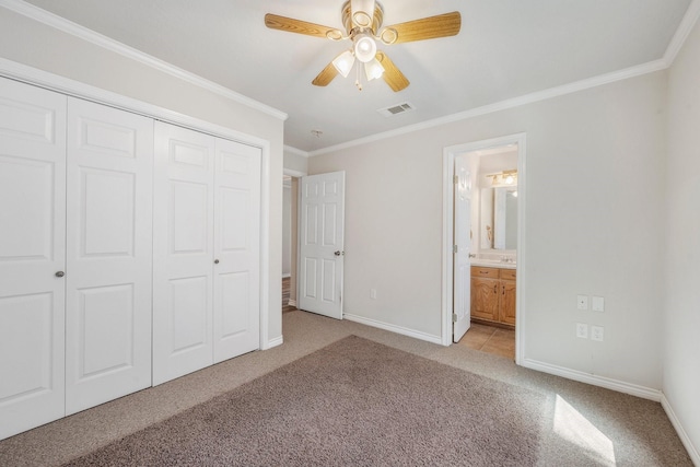 unfurnished bedroom with crown molding, a closet, light colored carpet, visible vents, and baseboards