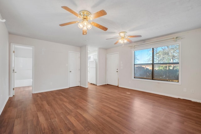 interior space featuring ceiling fan, baseboards, wood finished floors, and freestanding refrigerator