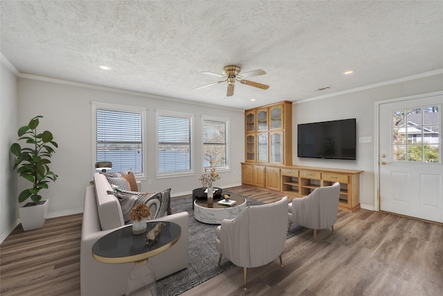 living room featuring light wood finished floors, visible vents, and crown molding