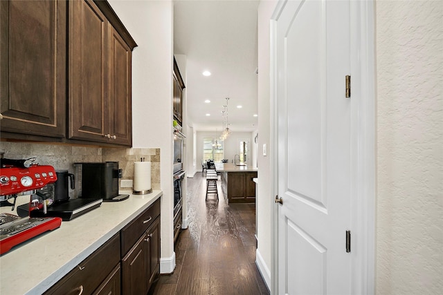 26407 Katy Springs Ln, Katy, TX 77494 - kitchen with dark wood-style floors, light countertops, decorative backsplash, dark brown cabinets, and baseboards