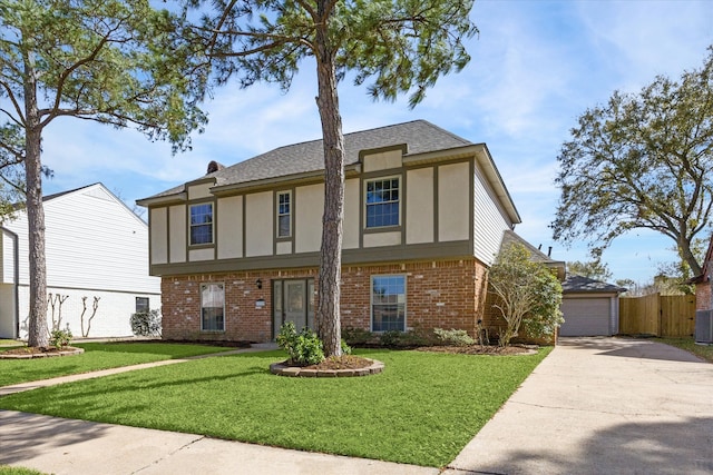 tudor home with brick siding, a front lawn, fence, and stucco siding