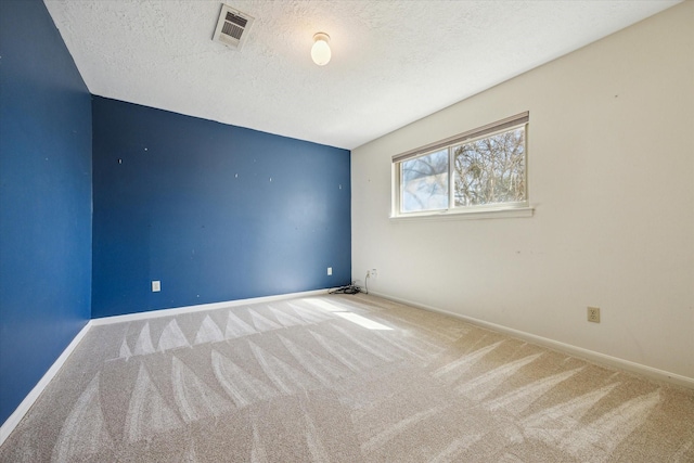 unfurnished room with a textured ceiling, carpet, visible vents, and baseboards