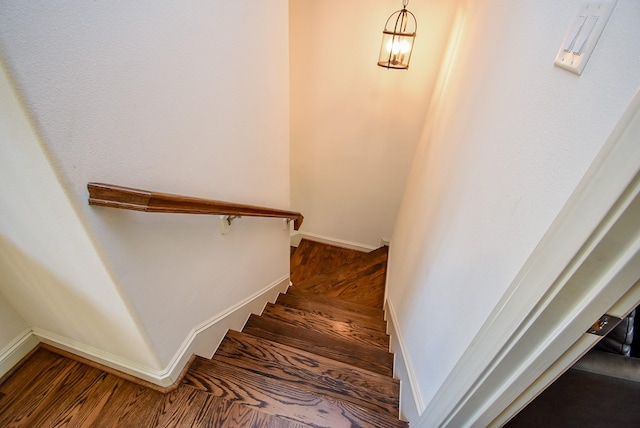 staircase with baseboards and wood finished floors