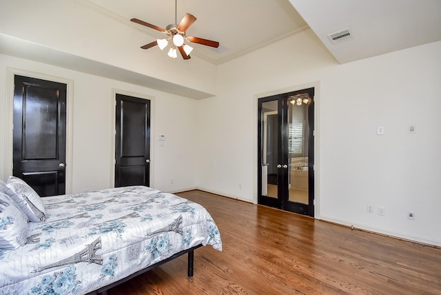 bedroom featuring ceiling fan, wood finished floors, visible vents, and baseboards