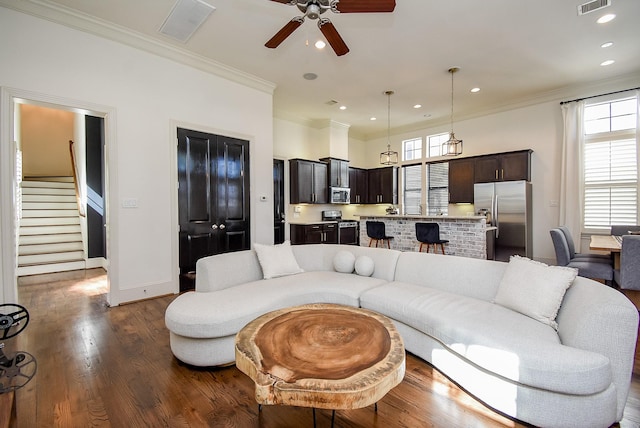 living area with ornamental molding, dark wood-style flooring, visible vents, and recessed lighting