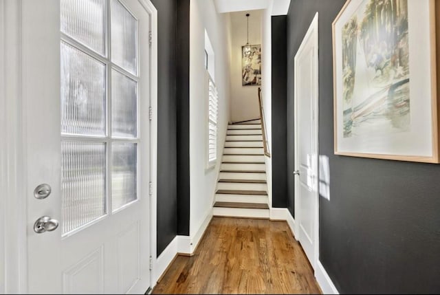 entryway with baseboards, stairway, and wood finished floors