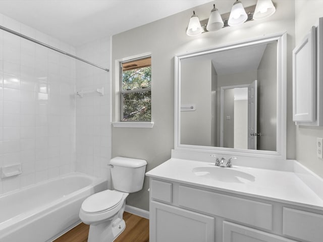 full bathroom featuring toilet, shower / bath combination, wood finished floors, vanity, and baseboards