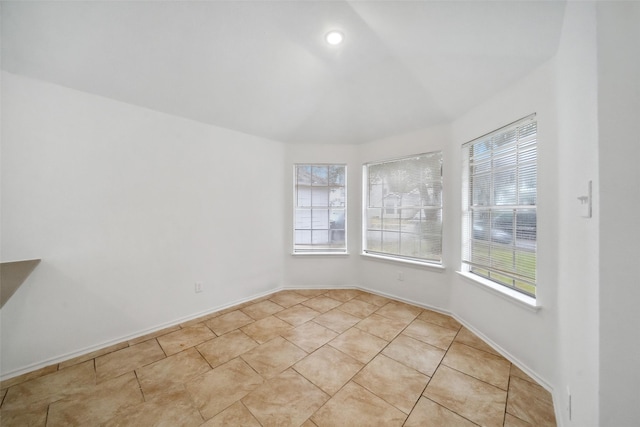 unfurnished room featuring baseboards and light tile patterned flooring