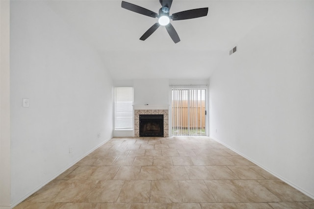 unfurnished living room with visible vents, baseboards, vaulted ceiling, a ceiling fan, and a tiled fireplace