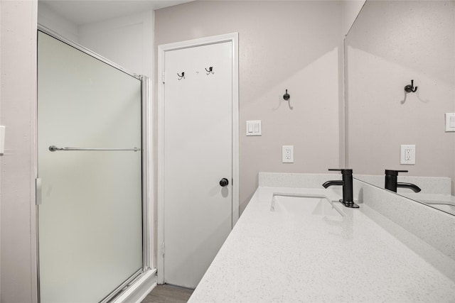 bathroom with a shower stall and vanity