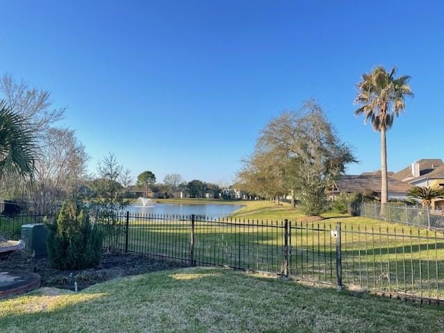 view of yard with a water view and fence