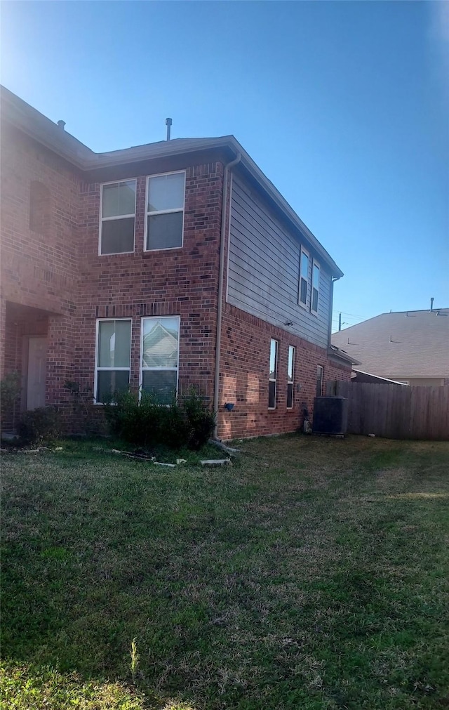 view of home's exterior featuring a lawn and brick siding