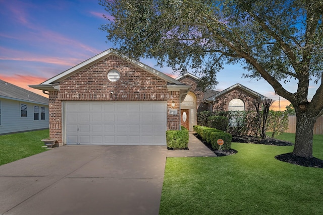 view of front facade featuring a garage, a yard, concrete driveway, and brick siding