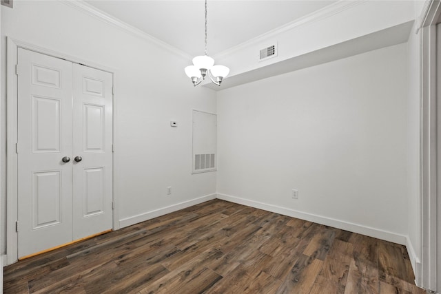 empty room with dark wood-type flooring, a chandelier, visible vents, and crown molding