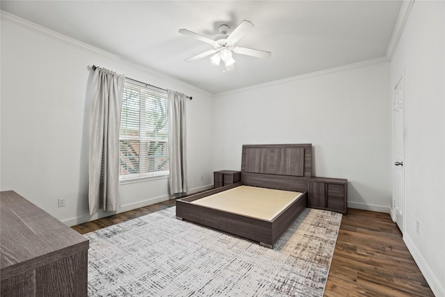 bedroom with baseboards, ceiling fan, wood finished floors, and crown molding